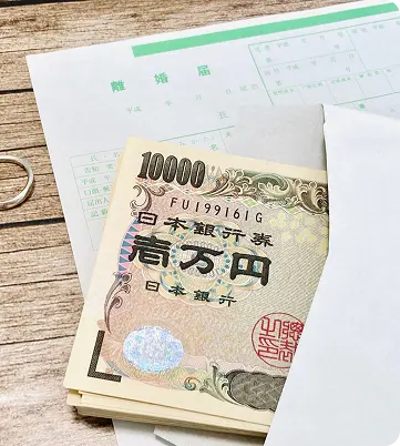 離婚届けとお金と指輪の写真