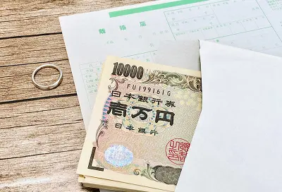 離婚届けとお金と指輪の写真